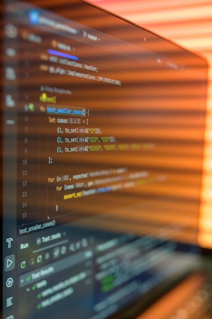 services-cta Close-up image of a computer screen displaying colorful programming code in a warm setting.